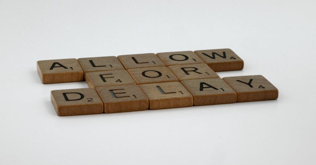 Wooden Scrabble tiles arranged on a white surface spelling 'Allow for Delay'.