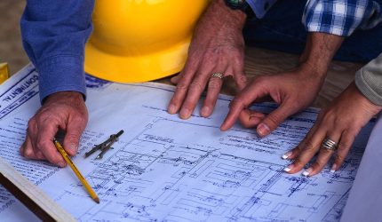 Hands of Couple Looking at Blueprints
